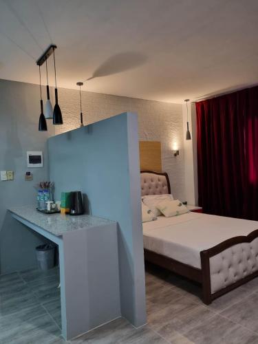 ein Schlafzimmer mit einem Bett und einer Theke mit einem Tisch in der Unterkunft Jewel's Hotel in Polomolok