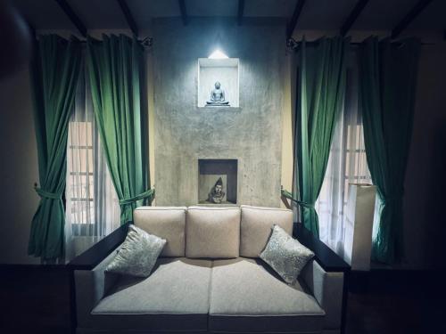 a living room with a couch and two windows at NILGIRA VILLA By LILYS in Badulla
