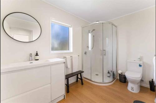 ein weißes Badezimmer mit Dusche und Toilette in der Unterkunft Modern Lake View House in Mangakino