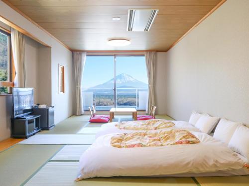 a bedroom with a large bed with a view of a mountain at Shoji Mount Hotel in Fujikawaguchiko