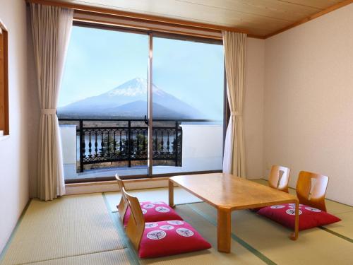 a room with a table and a view of a mountain at Shoji Mount Hotel in Fujikawaguchiko
