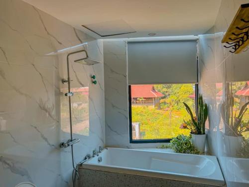 a bathroom with a bath tub and a window at Mộc Châu House in Mộc Châu
