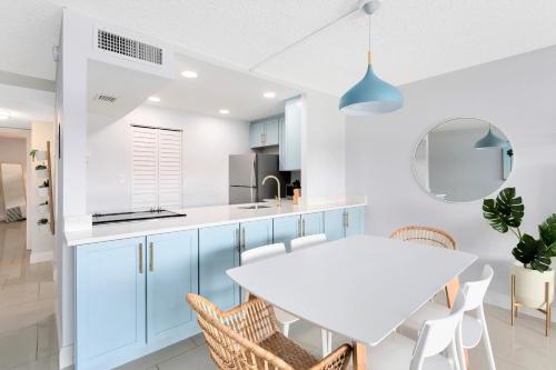 una cucina con tavolo e sedie bianchi di Chateau by the Sea 302 a Cocoa Beach
