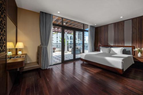 een slaapkamer met een bed en een glazen schuifdeur bij Palazzo Luxury Hotel & Bistro - Central My Khe Beach Walking Street in Da Nang