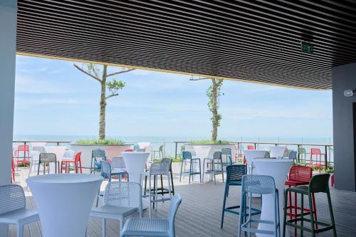 Nam KhêFlamingo Hai Tien的一排椅子和桌子摆放在面向大海的甲板上