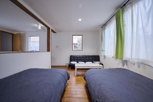 une chambre avec deux lits et un canapé dans l'établissement Casa Allegra, à Yamanakako