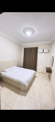 a bedroom with a white bed and a window at عماره 11 in 6th Of October