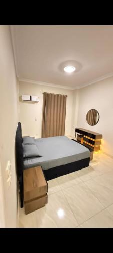 a bedroom with a large bed and a desk at عماره 11 in 6th Of October