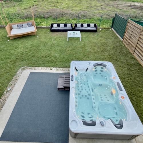 a hot tub in the middle of a yard at Maison entiere jacuzzi reception ouverte 7 7j et 24 24h in Ambarès-et-Lagrave