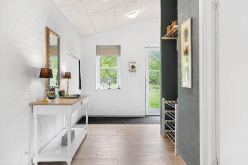 een gang met witte muren en een witte wastafel en een spiegel bij HA375-Saeby-Kulmulevej-21 in Sæby