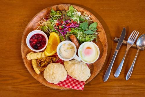 une assiette de nourriture avec une salade, du pain et des sauces dans l'établissement Casa Allegra, à Yamanakako