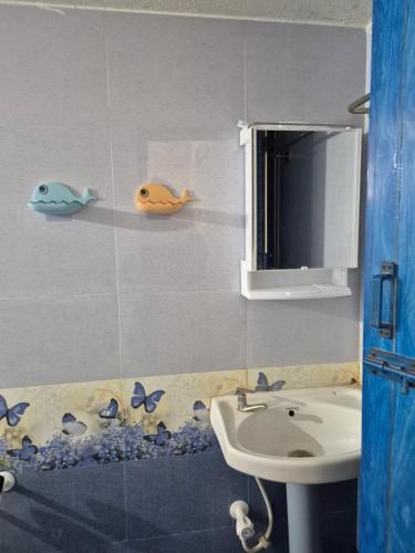 a bathroom with a sink and some fish on the wall at STM StayInn in Nāttarasankottai