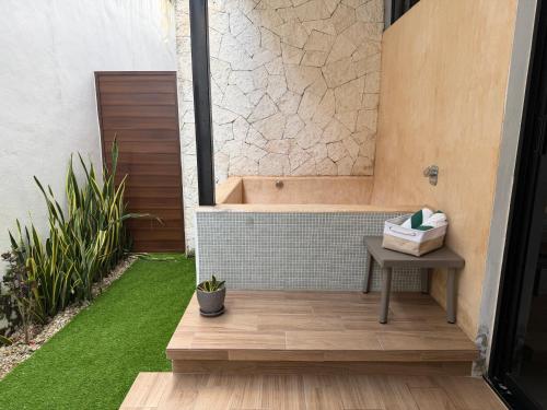 ein Badezimmer mit Badewanne, Tisch und Rasen in der Unterkunft Penca Suites Valladolid in Valladolid