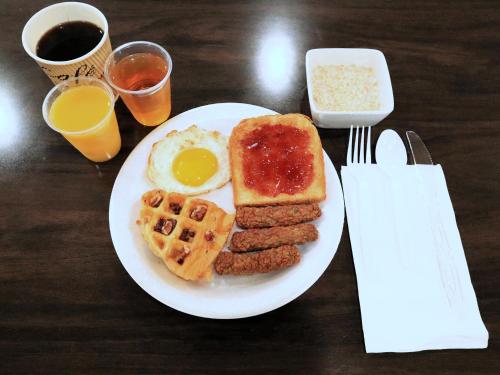 een bord ontbijtproducten met eieren, worst en wafels bij Americas Best Value Inn Suites & Studios Blytheville by Sonesta in Blytheville