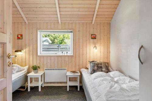 una piccola stanza con un letto e una finestra di HA384-Hals-Brombaervej-16 a Hou