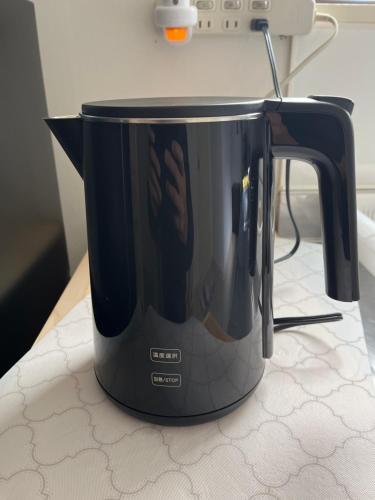 een zwarte broodrooster op een aanrecht bij Shinehouse2 in Kawaguchi