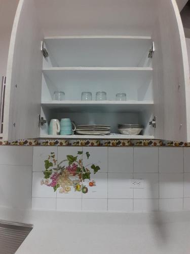 a white kitchen with a counter with flowers on it at Suite cerca de la UTPL y Centro Histórico in Loja