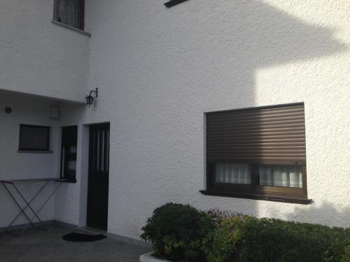 a white building with a window with a shutter at Casa Dos Cabecinhos in Paradamonte