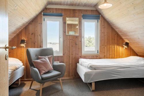 a bedroom with a bed and a chair and window at 300-Harboore-Fourmivej-29 in Harboør