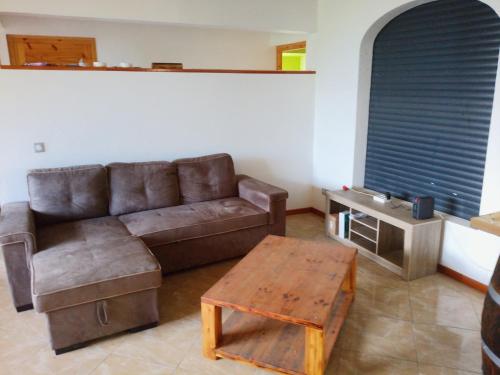 een woonkamer met een bruine bank en een tafel bij kaz a gabou in Sainte-Rose