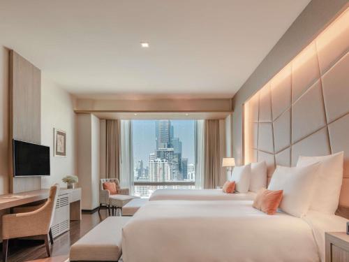 une chambre d'hôtel avec un grand lit et une grande fenêtre dans l'établissement VIE Hotel Bangkok - MGallery Collection, à Bangkok