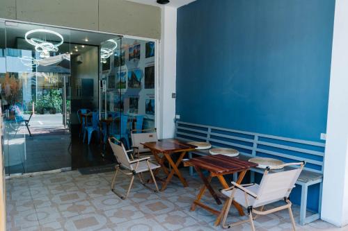 een tafel en stoelen voor een blauwe muur bij Happyhome Hostel in Ban Pho Touane