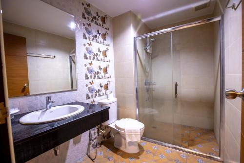 a bathroom with a toilet and a sink and a shower at Huen Jao Ban Hotel in Chiang Mai
