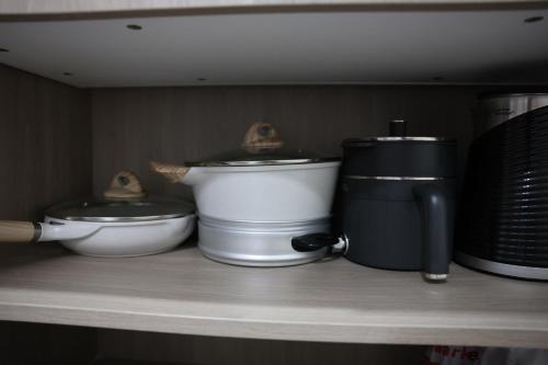 ein Regal mit zwei Töpfen und einer Kaffeemaschine in der Unterkunft Eirene Place Relax and Recharge in Pusok