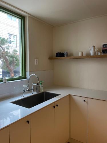 een keuken met een spoelbak en een raam bij Stay early mansion in Incheon