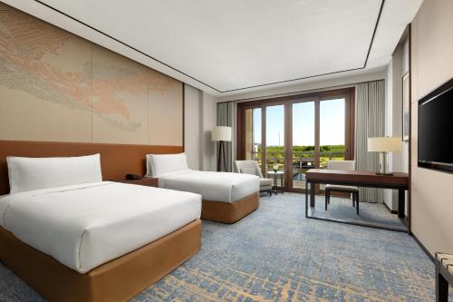 Giường trong phòng chung tại HUALUXE Qidong