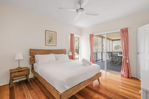 een slaapkamer met een bed en een glazen schuifdeur bij Oceanfront Escape Kilcunda in Kilcunda