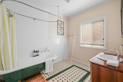 een witte badkamer met een bad en een wastafel bij Oceanfront Escape Kilcunda in Kilcunda