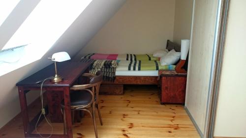 a small bedroom with a bed and a desk at Two-level apartment with fireplace in Trakai