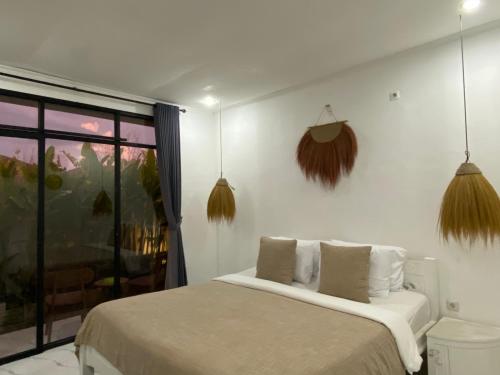 una camera da letto con un letto e una finestra di Yuli Homestay a Uluwatu