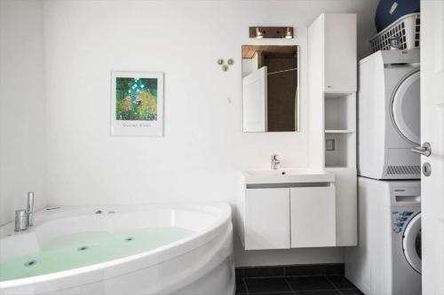 a white bathroom with a tub and a sink at 323-Harboore-Skalvej-4-a in Harboør