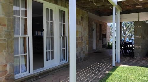 a screened porch with sliding glass doors on a house at River Dawn in Shoalhaven Heads
