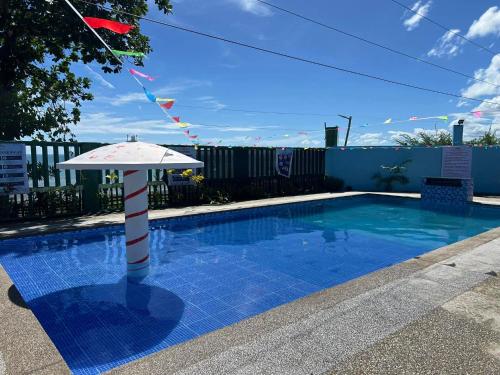 een zwembad met een parasol naast een hek bij Solaya Cove Private Resort in Bansud