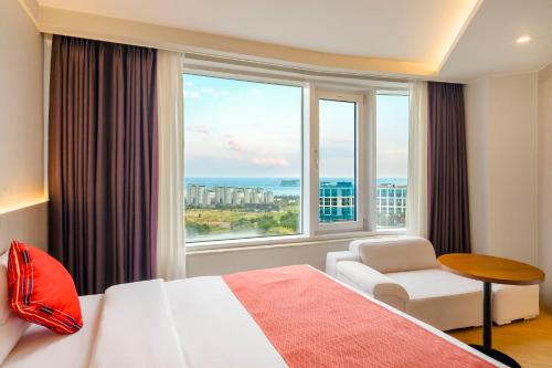 Postel nebo postele na pokoji v ubytování Shin Shin Hotel Jeju Worldcup