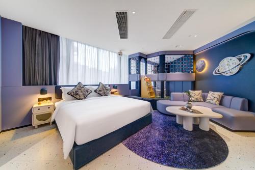 een slaapkamer met een groot bed en een bank bij 珠海复登临酒店 Relanding Hotel in Zhuhai