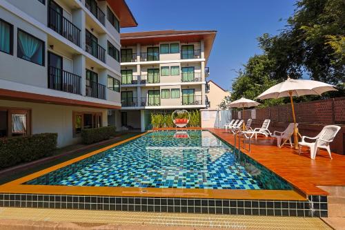 a swimming pool in front of a building at Huen Jao Ban Hotel in Chiang Mai