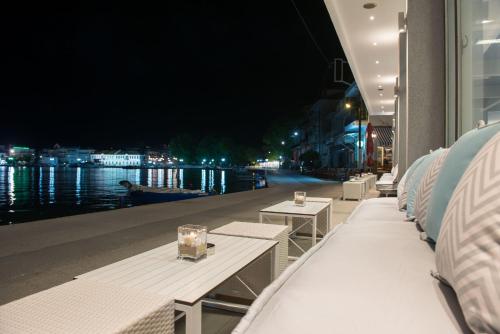 a row of white benches with a view of the water at Angelica Hotel in Limenas