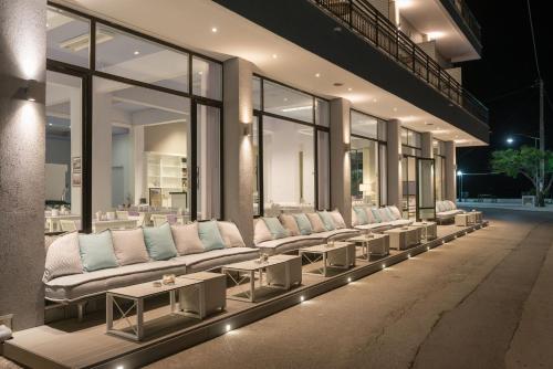 a row of white couches and tables in a building at Angelica Hotel in Limenas