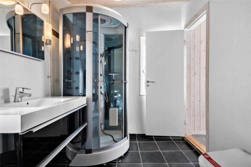 een badkamer met een glazen douche en een wastafel bij 0018-Romo-Trinnesvej-16 in Bolilmark