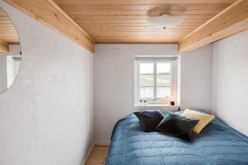 a bedroom with a blue bed with a wooden ceiling at 0002-Romo-Juvrevej-89 in Høm