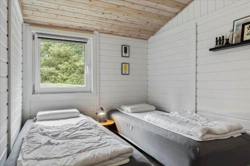 een kamer met 2 bedden en een raam bij 0001-Romo-Blabaervej-23 in Bolilmark