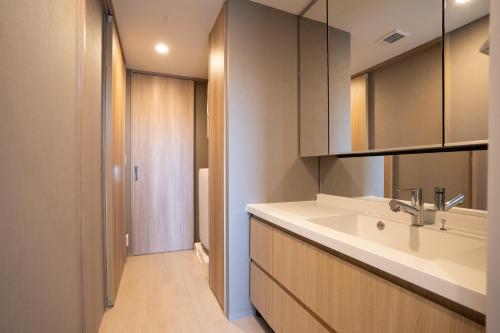 een badkamer met een wastafel en een spiegel bij KAI Okinawa in Kitanakagusuku