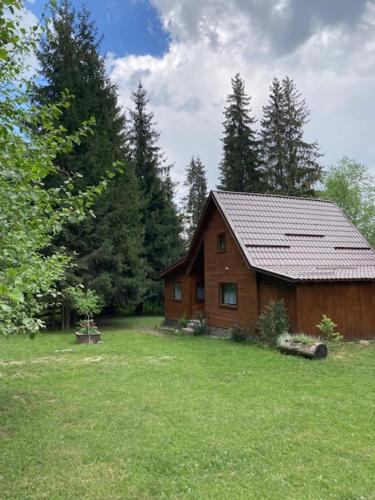 een houten huis in een veld van groen gras bij Pin chalet in Borzont