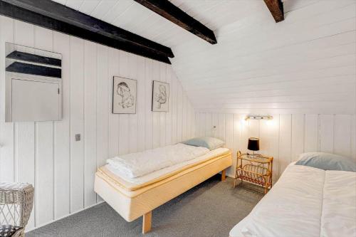 a bedroom with two beds in a white wall at 0005-Romo-Moritzvej-5 in Høm