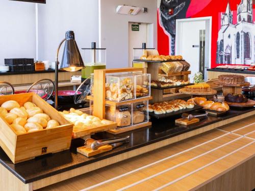 ein Buffet mit verschiedenen Brotsorten und Gebäck in der Unterkunft ibis Ourinhos in Ourinhos