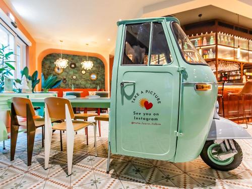 een oude Vespa geparkeerd bij een restaurant bij Hotel Ibis Lisboa Parque das Nações in Lissabon